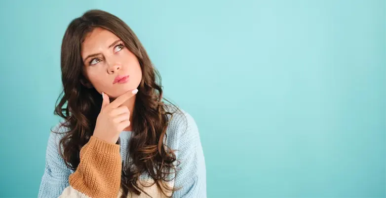attractive-thoughtful-girl-knitted-sweater-dreaming-blue-background